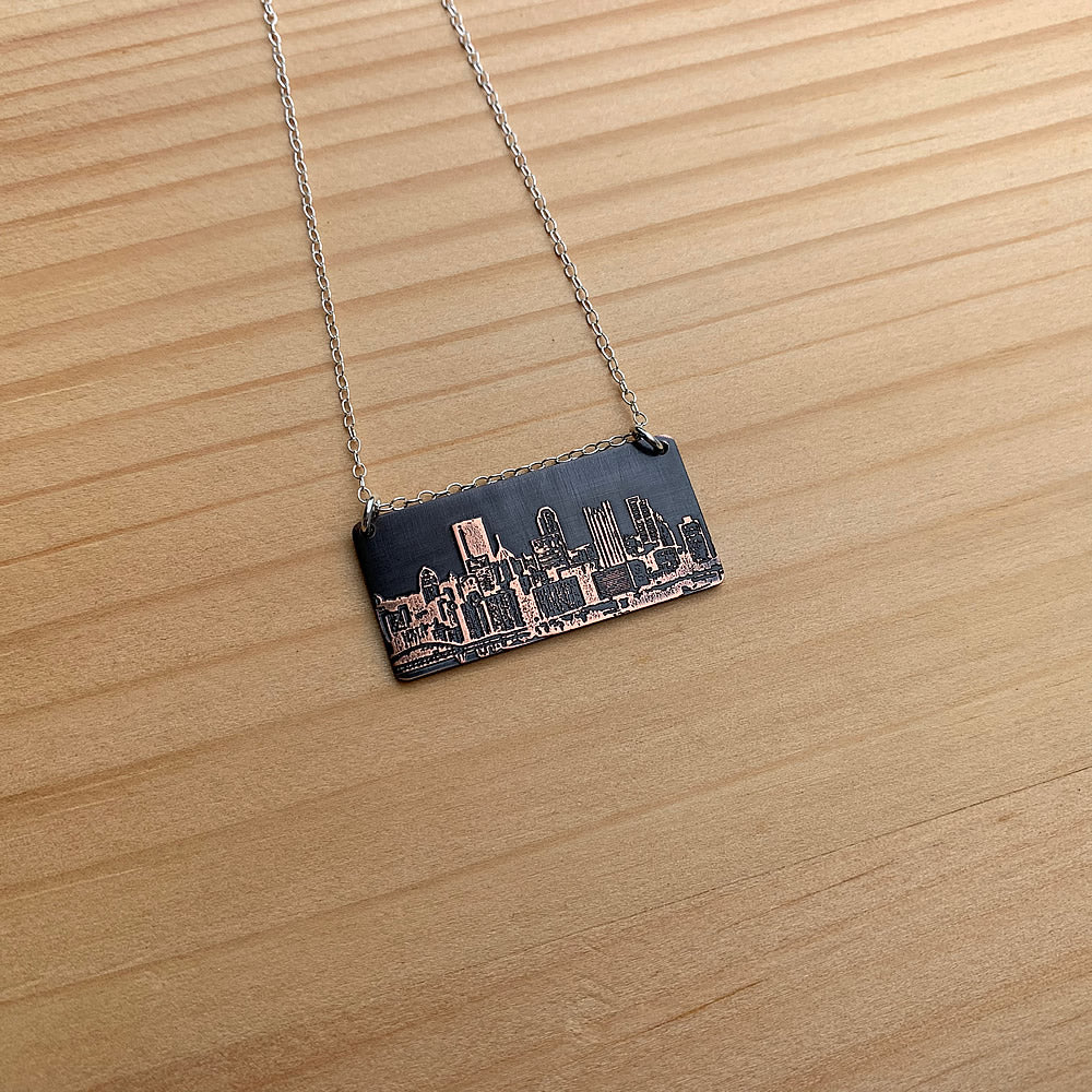 dark copper pittsburgh skyline pendant with sterling silver chain handmade jaci riley jewelry