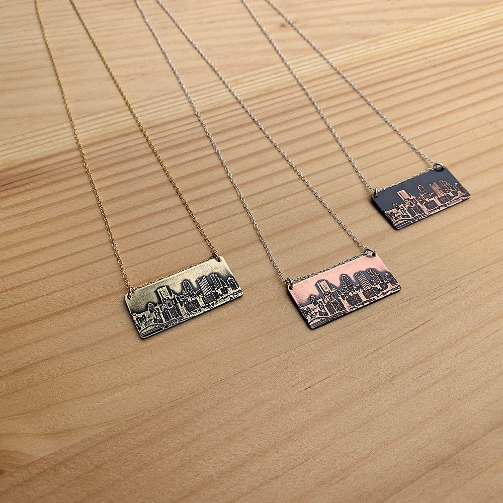 group of pittsburgh skyline pendants on wooden background