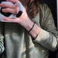 onyx bracelet on person holding a coffee mug