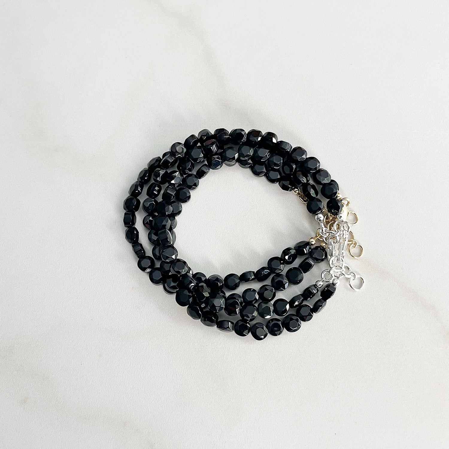 group of onyx bracelets in a stack on a white background