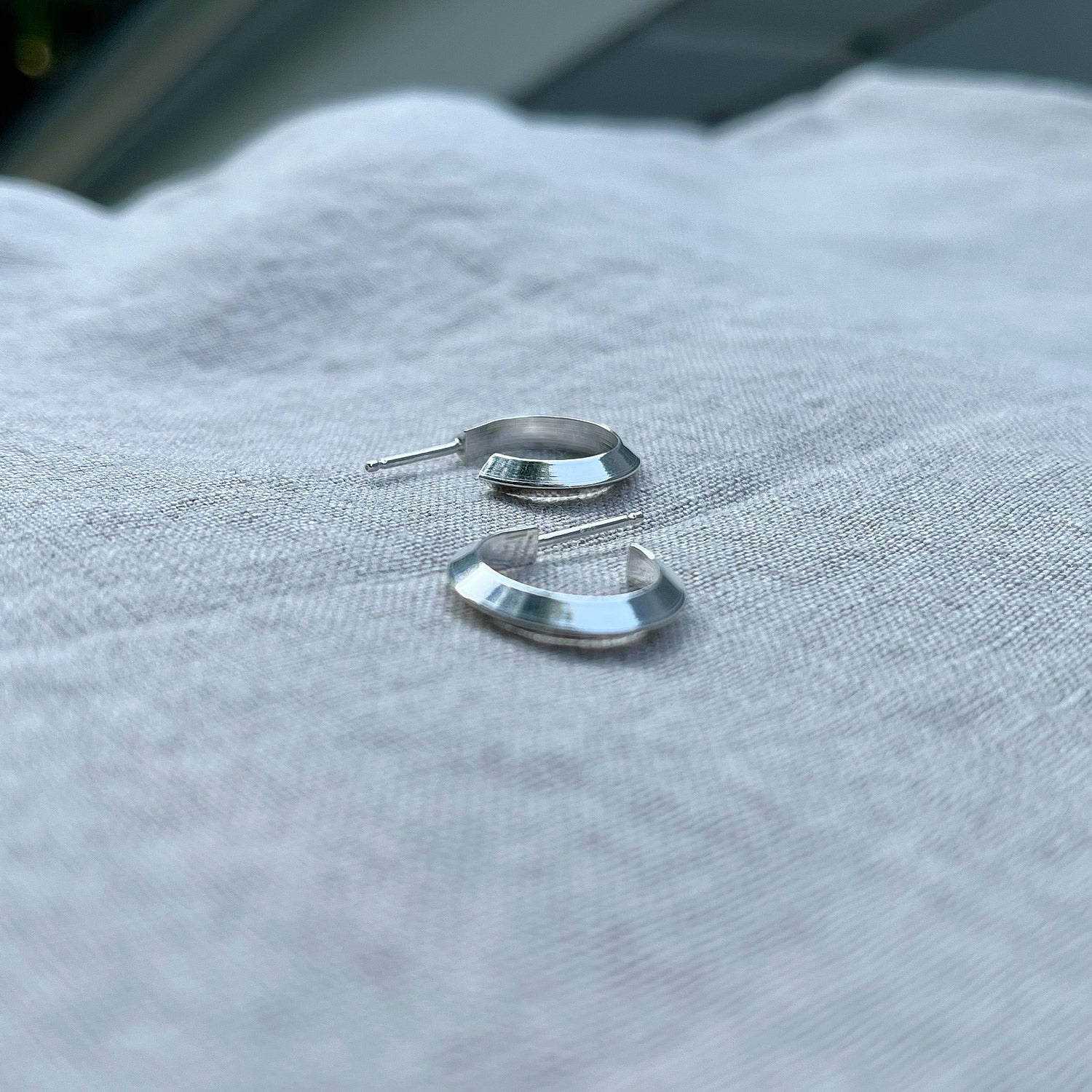sterling silver hoop earrings on a linen back drop