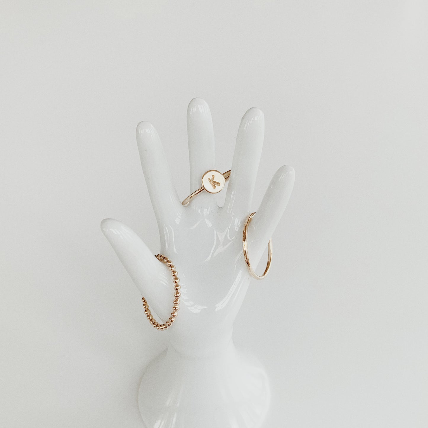 stacking rings on hand statue in gold