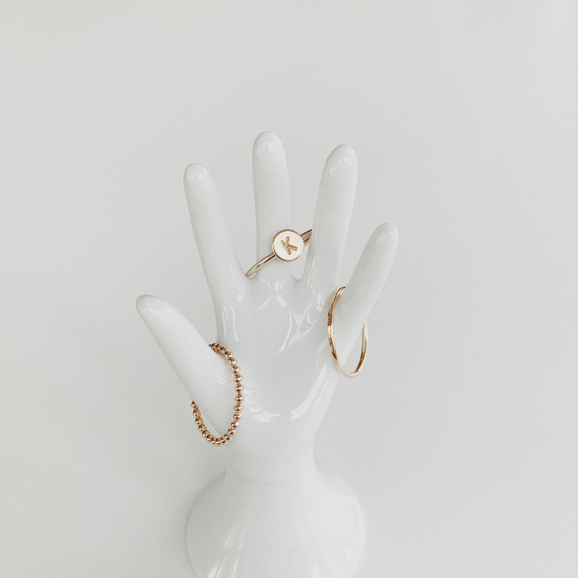 stacking rings on hand statue in gold