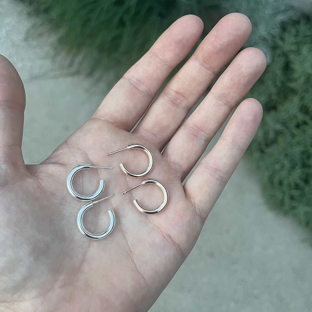sterling silver and 14k gold filled hoops in a hand