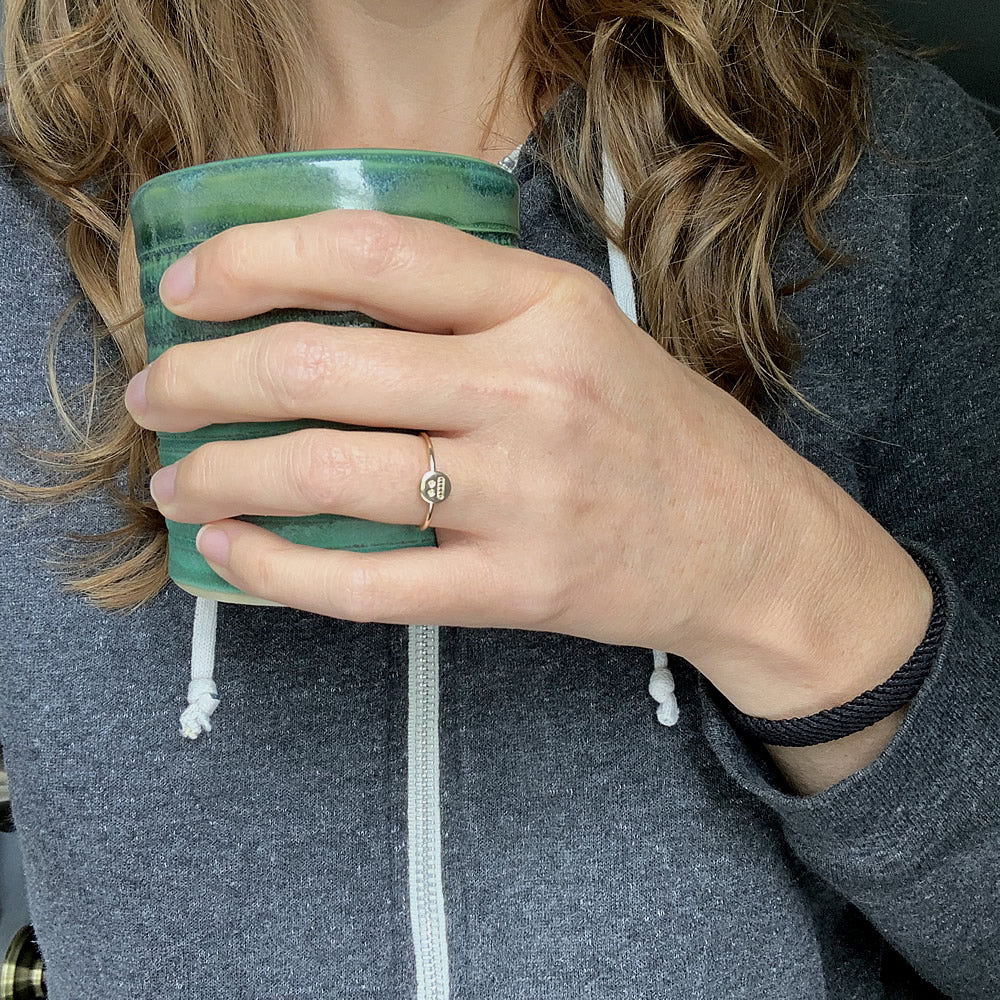 gold fillled cringe ring on hand holding a mug