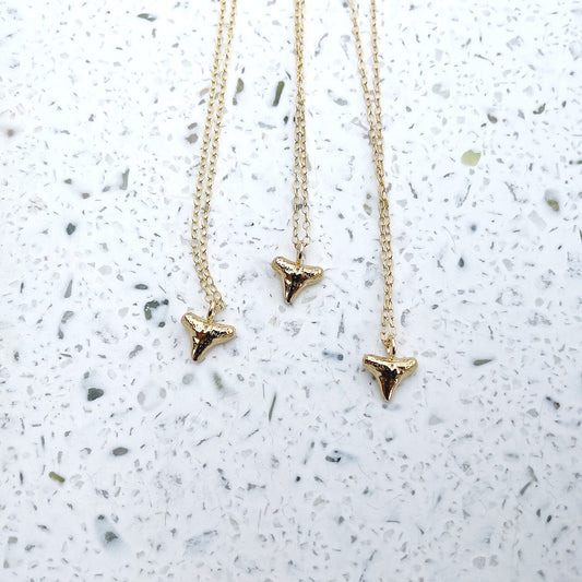 3 gold shark tooth necklaces in gold vermeil with 14k gold filled chain on terrazo background
