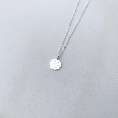 sterling silver smiley face neckalce on a white background