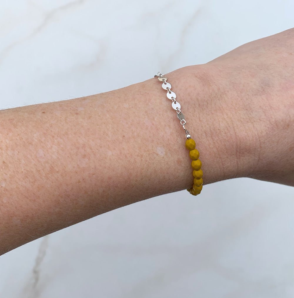 beaded bracelet with yellow glass beads and silver coin chain, worn on wrist